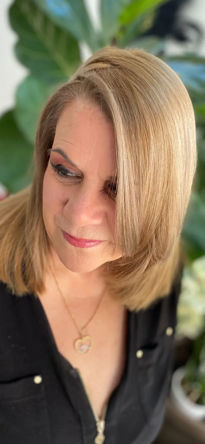 Shoulder-length blonde bob with sleek blow-dry finish and warm dimensional color, client portrait