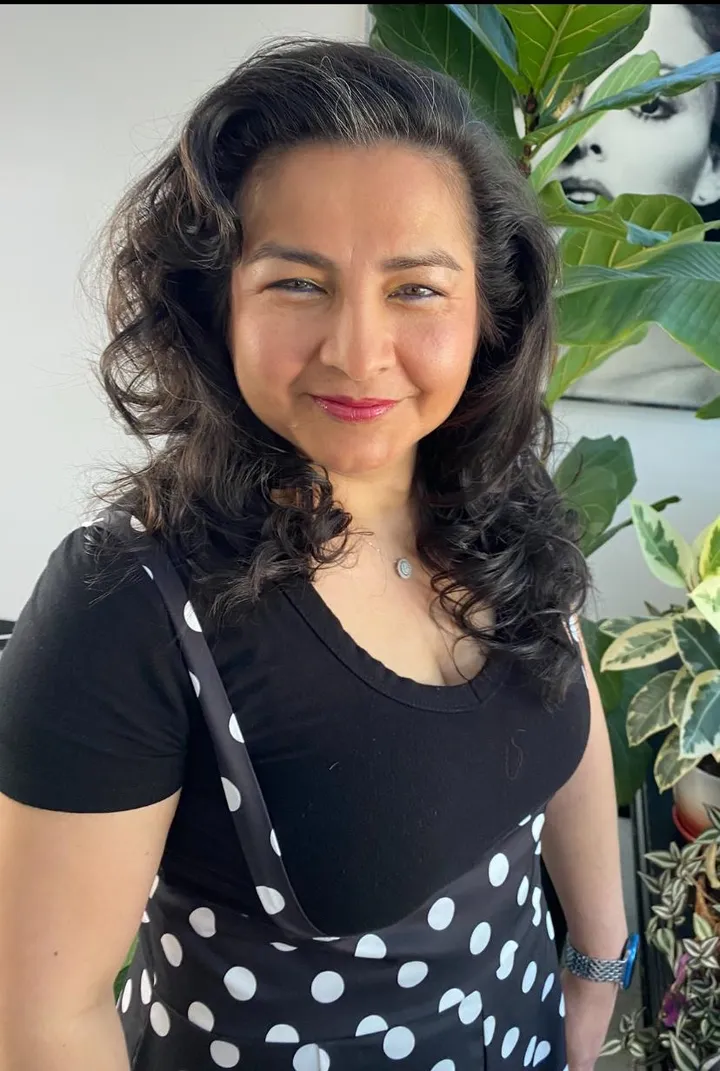 Dark brown hair with voluminous defined curls and soft volume, client portrait