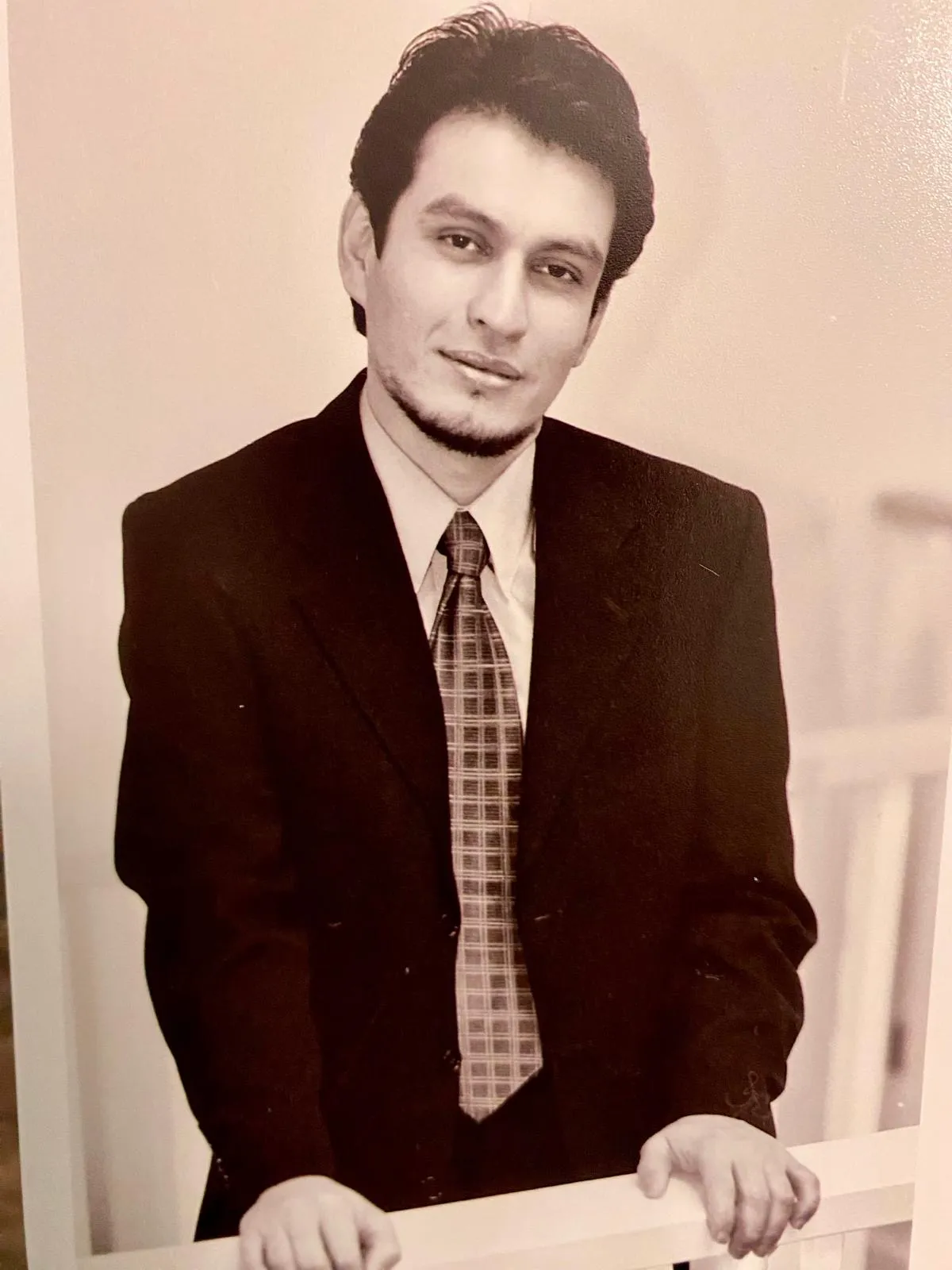 Archival sepia portrait of one of L.A. Monroe Hair Studio's founders in a dark suit and plaid tie