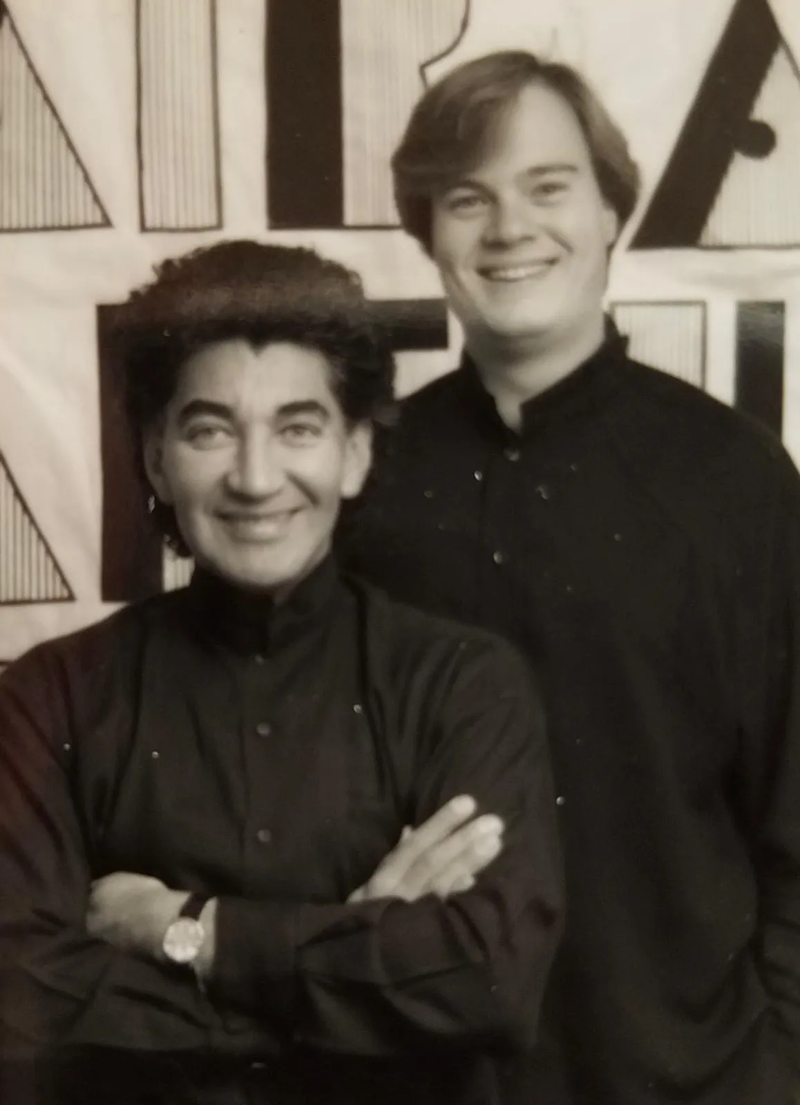 Archival black-and-white photograph of L.A. Monroe Hair Studio's founders in front of a graphic backdrop