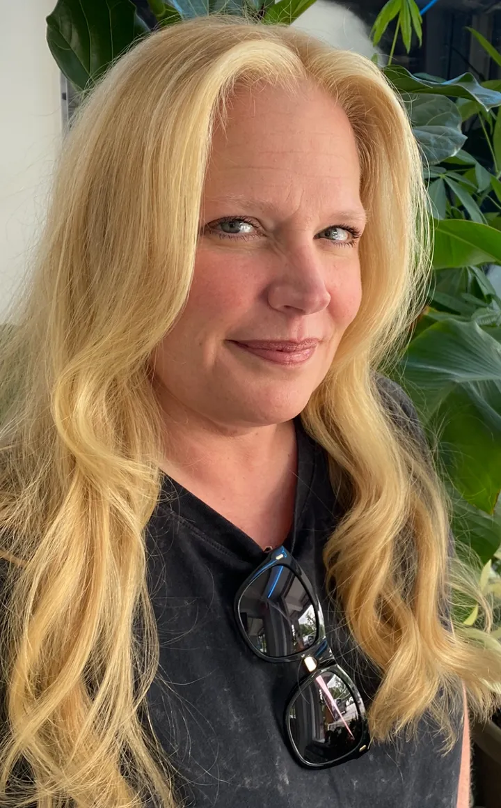 Long platinum-blonde hair with soft waves and natural finish, client portrait