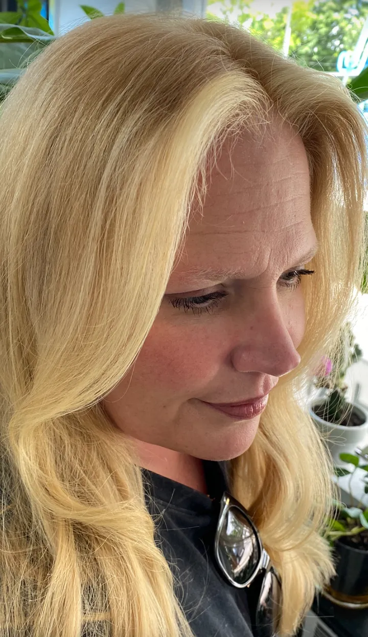 Side profile of long platinum-blonde hair with soft waves and a clean blow-dry finish