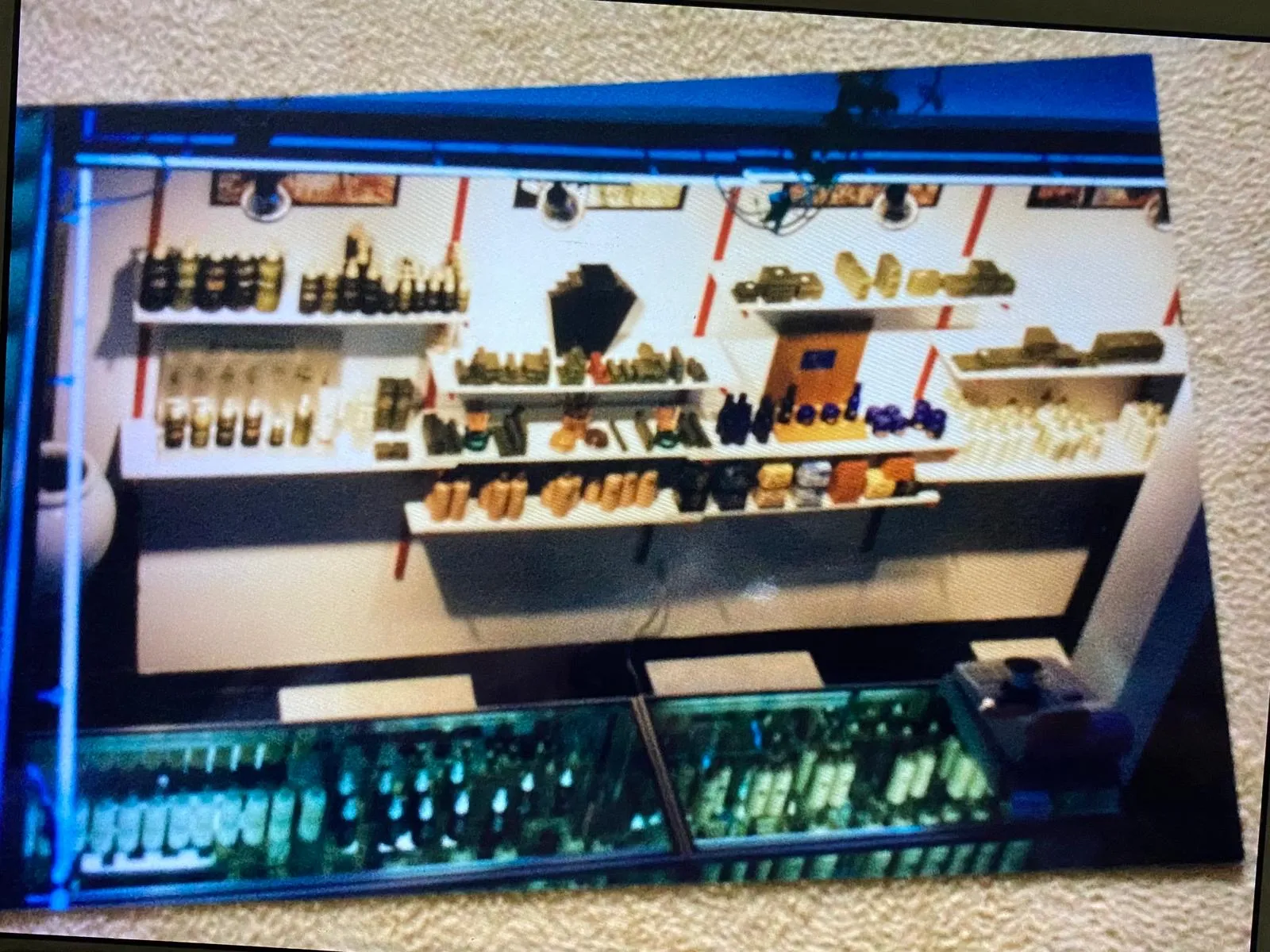Backlit product display shelves and glass case glowing under blue light inside the salon