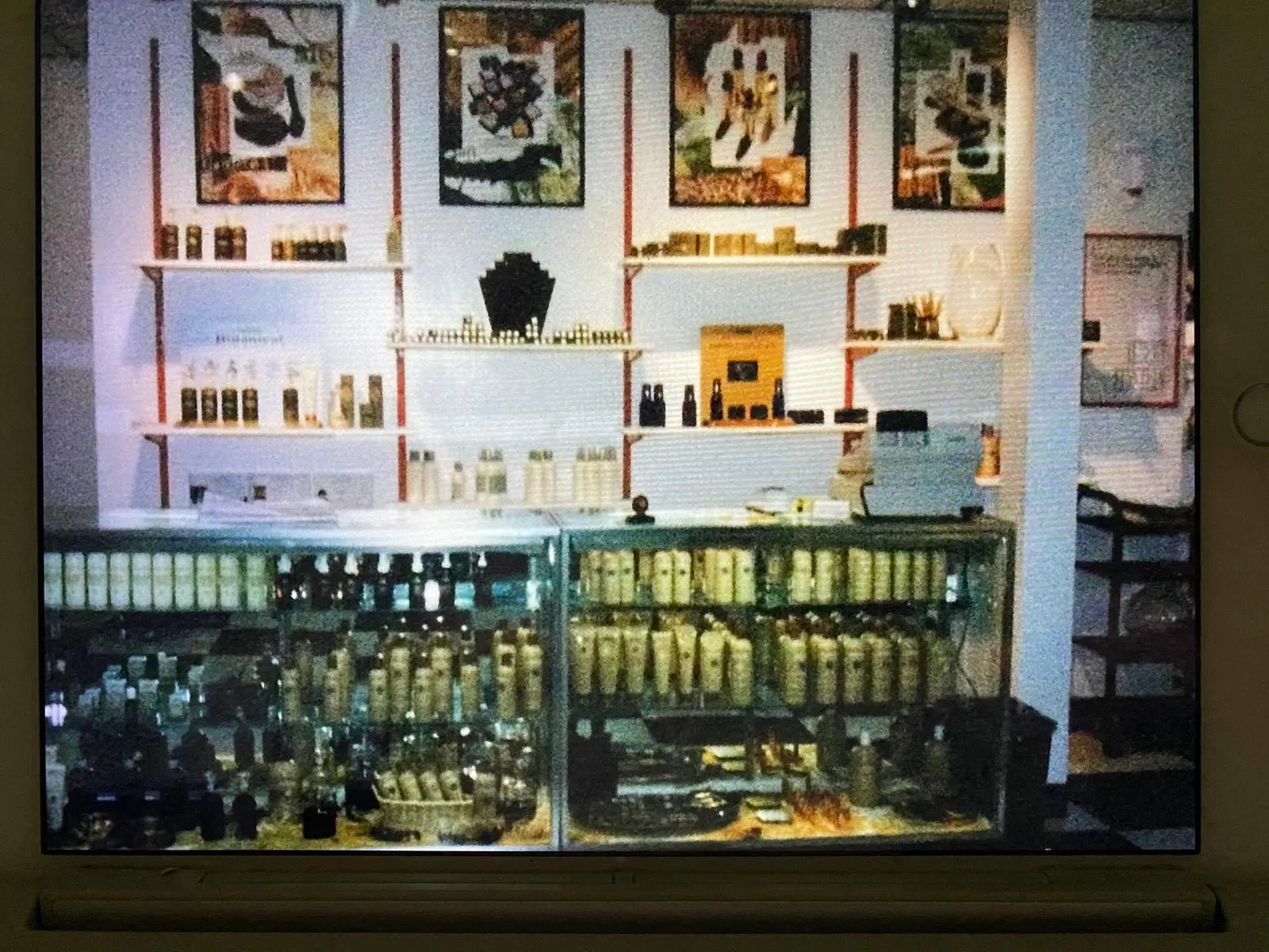 Product display counter stocked with hair care products beneath framed posters inside the salon