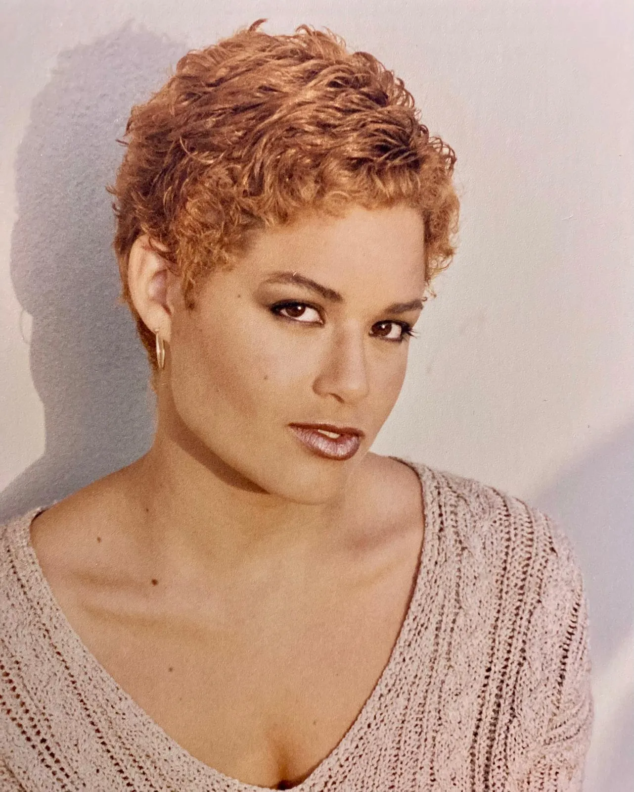 Short copper-red curly pixie cut with soft, layered texture