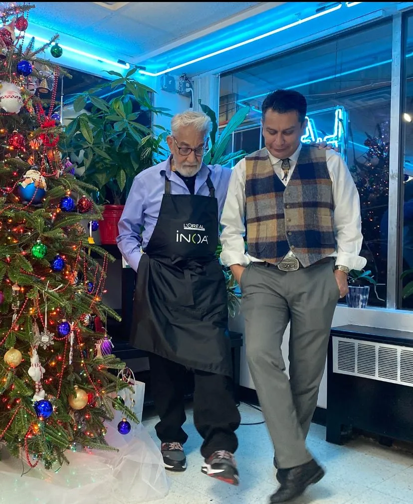 Two members of the L.A. Monroe Hair Studio team beside a decorated Christmas tree inside the salon