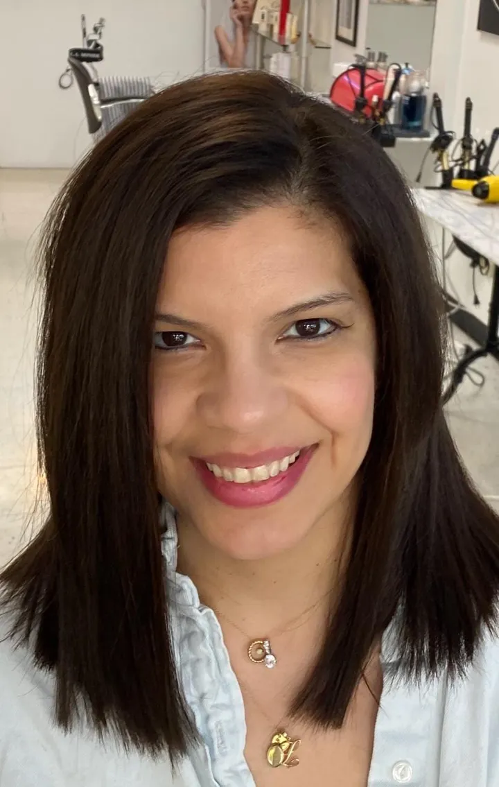 Sleek, glossy dark brown blowout falling past the shoulders